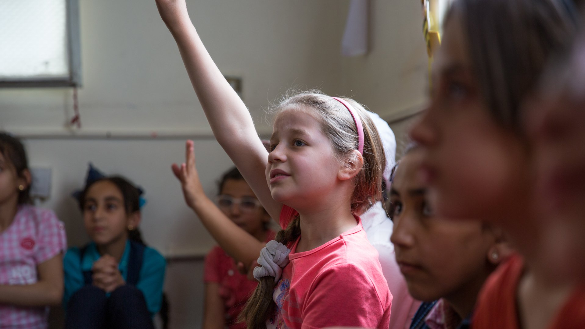 Meisje steekt haar hand op tijdens een I Deal sessie van War Child in Jordanie