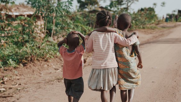 Oegandese kinderen in omhelzing lopend - War Child projecten in Oeganda